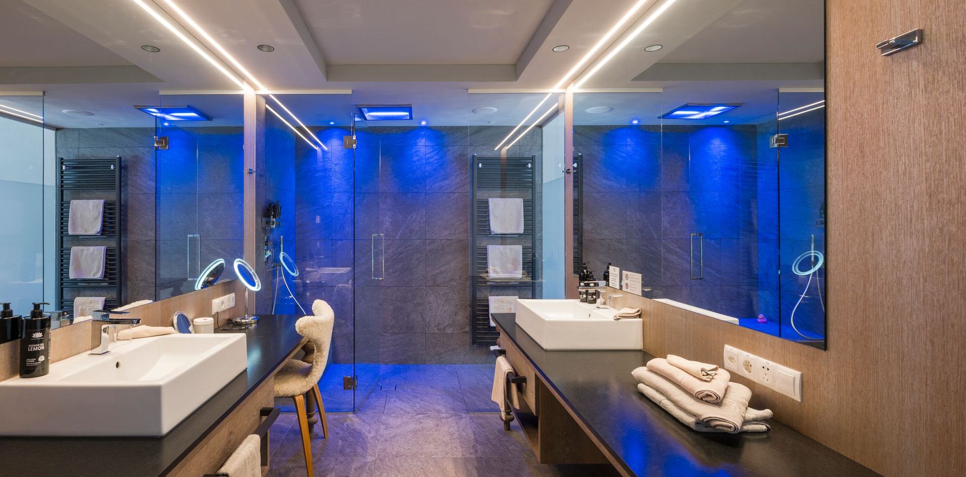 Ein moderner Badbereich mit zwei Waschbecken, Spiegeln und Holzdetails in der Luxury Suite You & Me Premium.