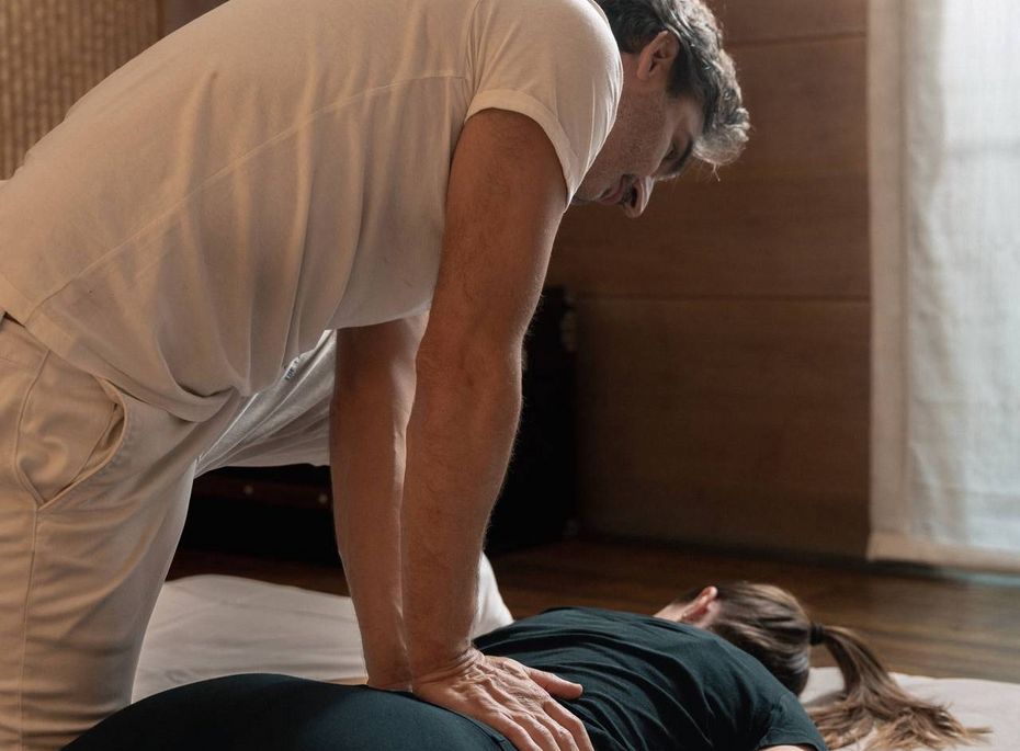 Massage im Wellnesshotel Preidlhof in Naturns Ein Masseur behandelt eine liegende Frau in einem ruhigen Behandlungsraum des Wellnesshotels.
