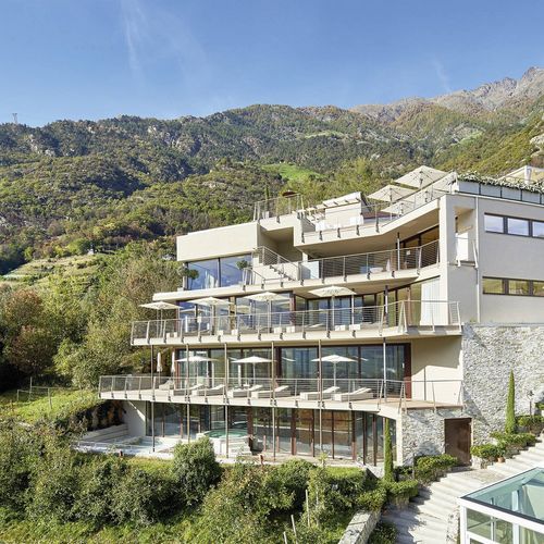 Das Preidlhof Resort liegt terrassenförmig am Hang vor einer Bergkulisse.