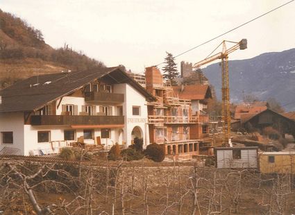 Ein historisches Foto zeigt den Preidlhof in Naturns während eines Umbaus mit Baugerüst und Kran.