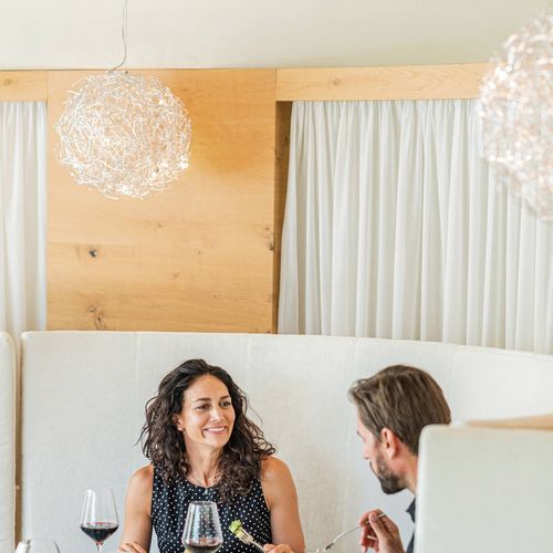 Ein Paar sitzt im Restaurant beim Essen und unterhält sich bei einem Abendessen mit Wein.