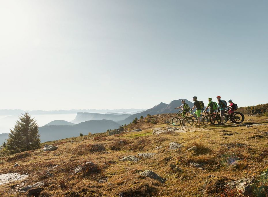 Mountainbike-Tour mit Bergblick in Südtirol Mehrere Mountainbiker stehen auf einem Höhenweg mit Blick über die Berglandschaft.