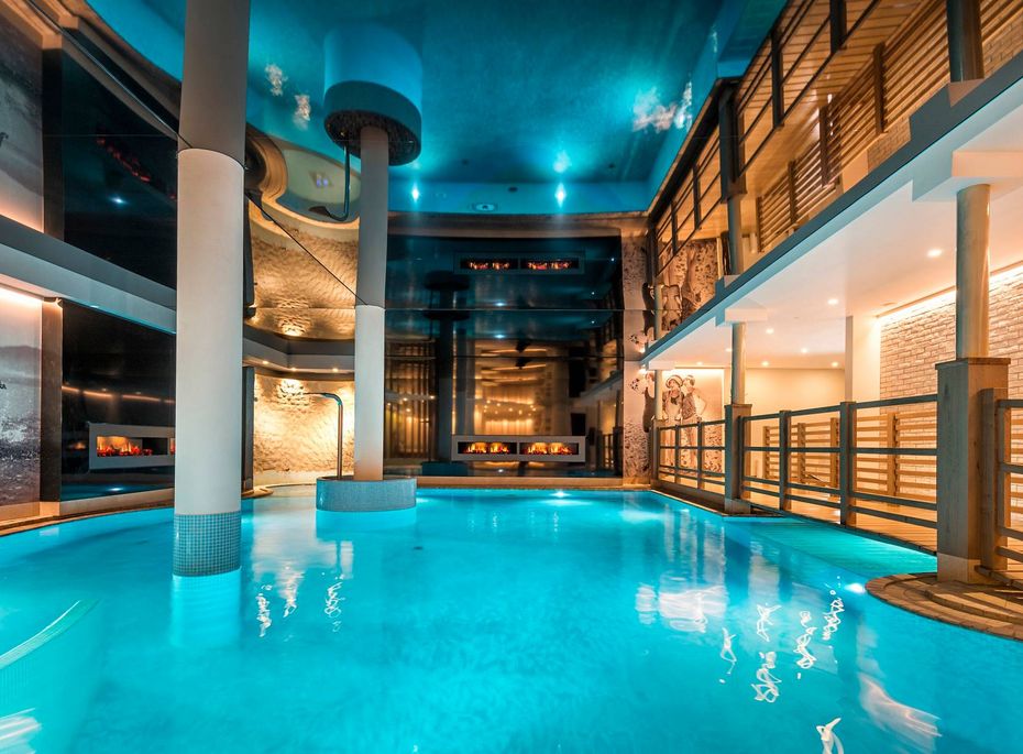Indoor Pool im Wellnesshotel Preidlhof Ein beleuchteter Indoor-Pool mit ruhigem Wasser in einem modernen Wellnessbereich.