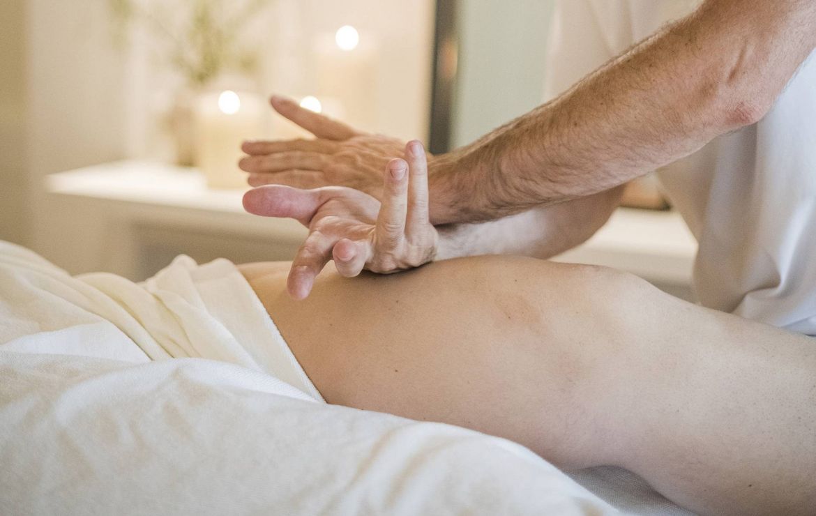 Un terapista applica pressione sulla schiena di un ospite durante un trattamento di massaggio spa.