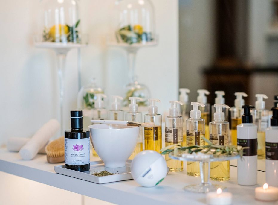 Auf einer Ablage stehen verschiedene Wellness-Produkte und Spenderflaschen im Spa-Bereich.