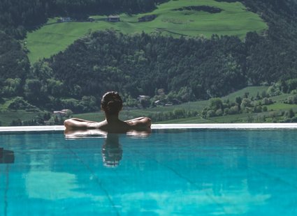Frau im Pool mit Blick auf die Landschaft