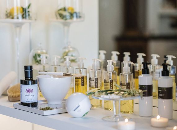 Auf einem hellen Tisch stehen verschiedene Pflegeprodukte und Flaschen für Beauty-Behandlungen.