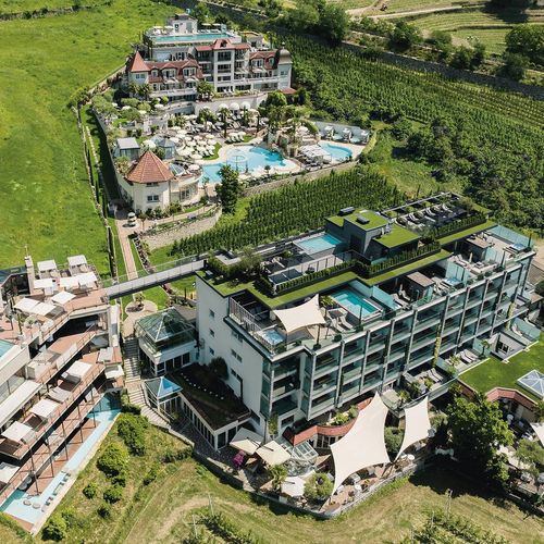 Luftaufnahme des Preidlhof Wellnesshotels mit Poolanlage, Terrassen und umliegenden Weinbergen in Naturns.