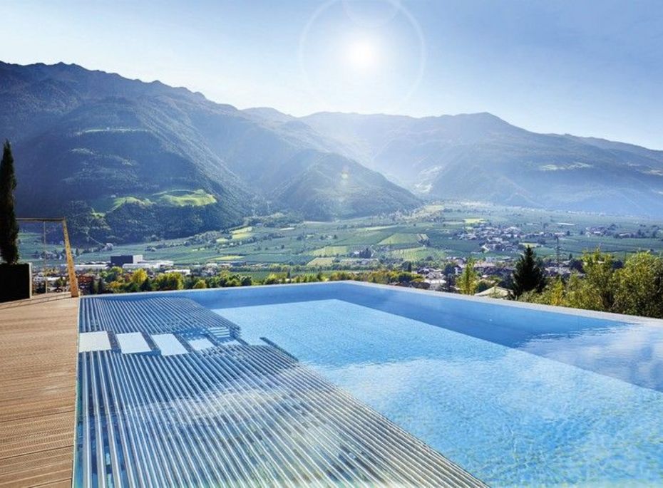 Ein Infinity-Pool mit Blick über das Tal und die Berge bei klarem Himmel.