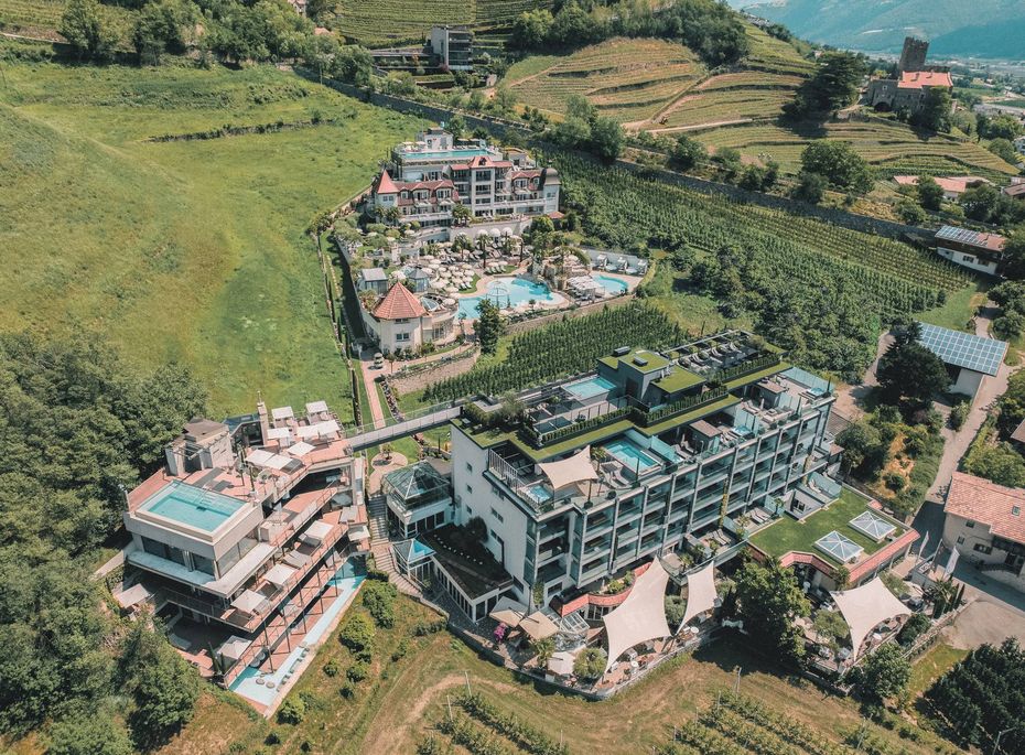 Luftaufnahme des Wellnesshotels Preidlhof in Naturns Luftaufnahme des Wellnesshotels mit Poolanlage, Terrassen und weitläufigen Rebhängen rund um das Preidlhof in Naturns.