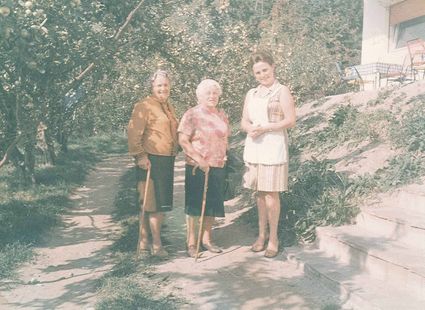 Drei Frauen der Gastgeberfamilie Ladurner stehen auf einem Gartenweg neben der Treppe.