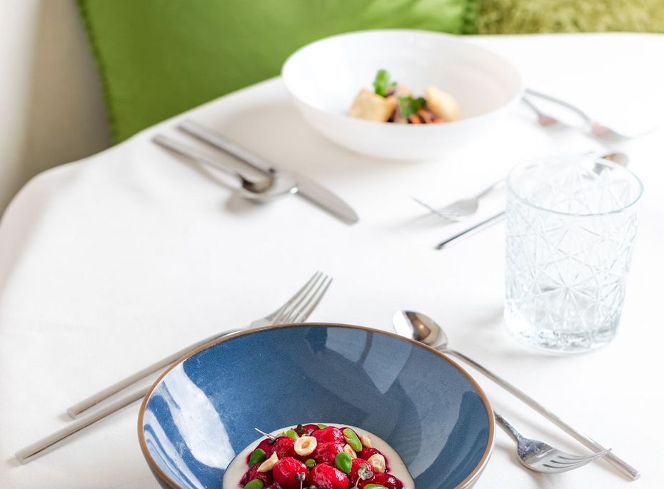 Gourmet-Tisch im Preidlhof Restaurant Ein gedeckter Tisch mit Teller, Besteck und Gläsern sowie zwei angerichteten Speisen im Preidlhof Restaurant.