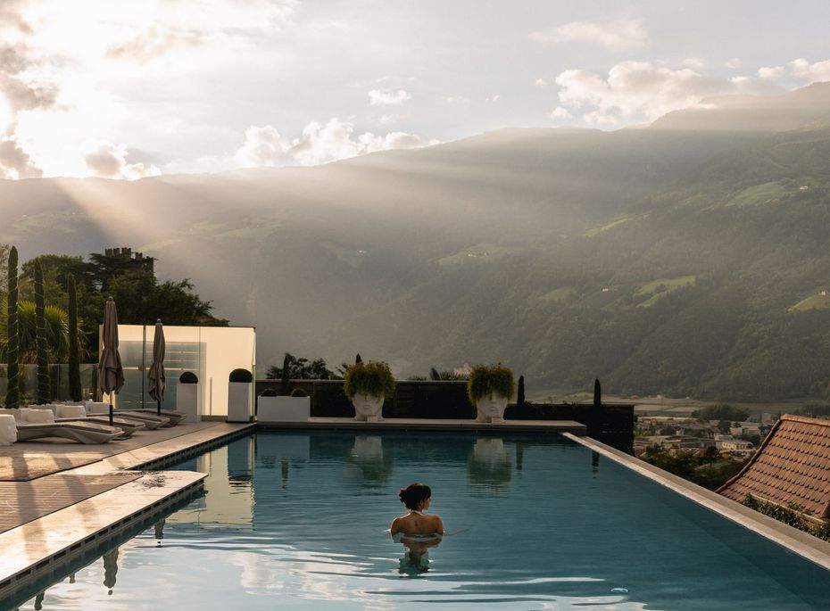 Infinity Pool mit Bergblick im Preidlhof Ein Infinity-Pool mit Blick auf die Berge im warmen Licht des Sonnenuntergangs.