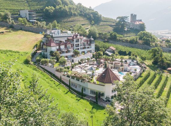 Un hotel wellness si trova tra terrazze di vigneti e colline verdi, con piscine esterne e terrazze solarium.