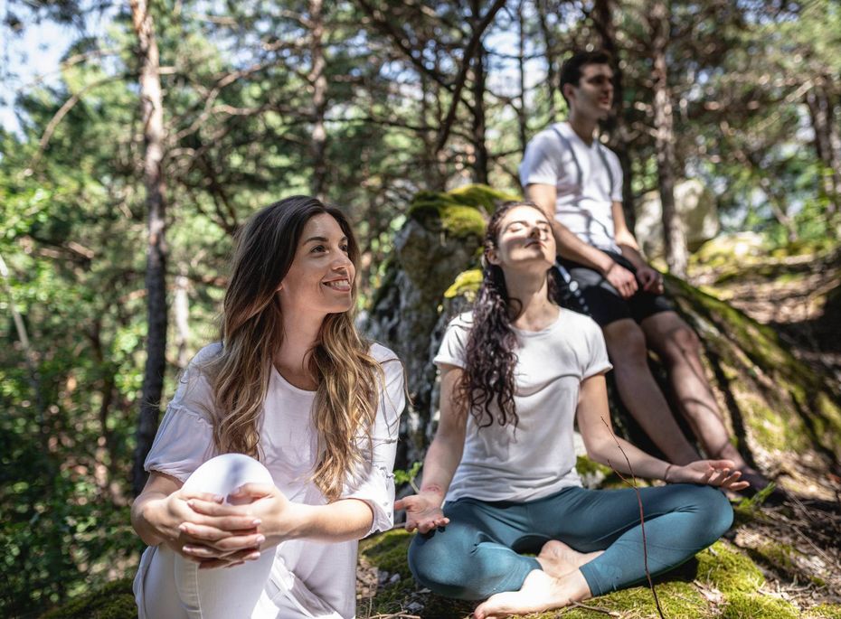 Wandergruppe im Wald beim Preidlhof in Südtirol Drei Personen sitzen im Wald auf moosigen Steinen und genießen eine ruhige Pause beim Wandern.