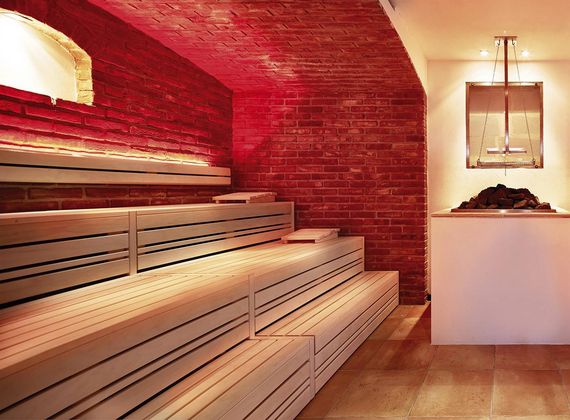Eine Sauna mit Holzbänken und rotem Ziegelgewölbe im Sauna Tower des Preidlhof.