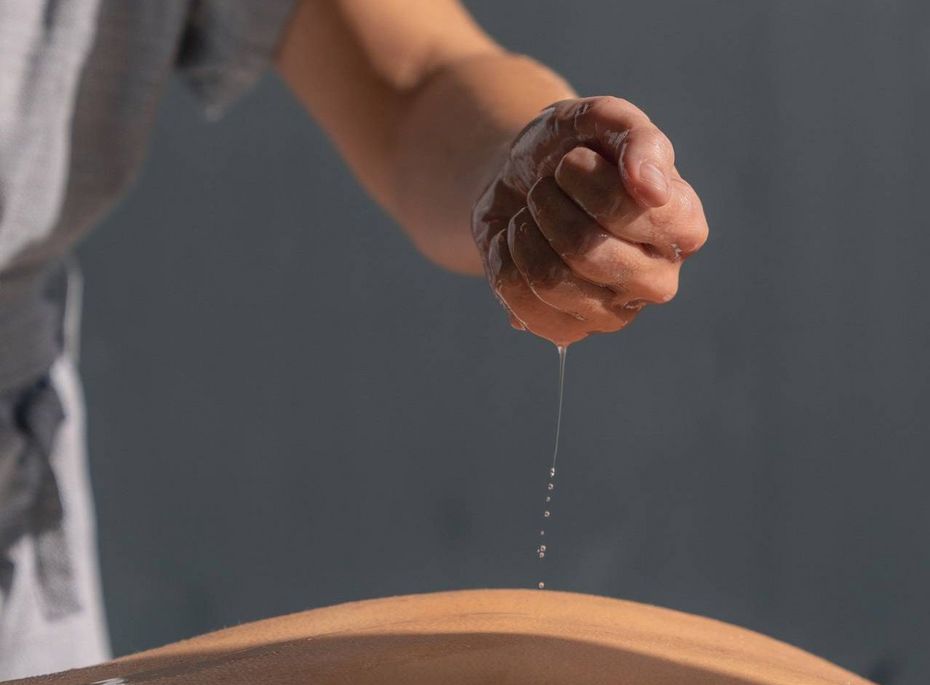 Massage im Spa im Preidlhof Eine Person lässt bei einer Spa-Anwendung Öl auf den Rücken des Gastes tropfen.