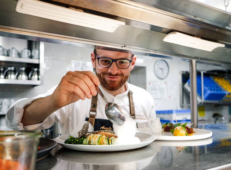 Gourmetküche im Preidlhof in der Hotelküche Ein Koch richtet in der Hotelküche ein Gourmetgericht auf einem Teller an.