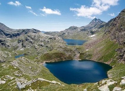 Blick auf zwei Bergseen in einer felsigen Hochgebirgslandschaft unter blauem Himmel.