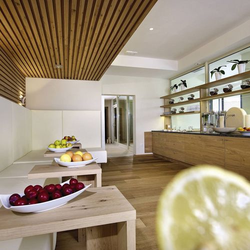 Ein heller Raum mit Holzdecke und Buffet mit verschiedenen Obstschalen im Spa-Bereich.