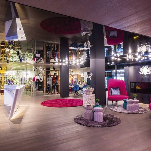 Eine stilvolle Wellness-Lounge mit pinken Sesseln, Spiegeldecke und dekorativen Elementen im Preidlhof.