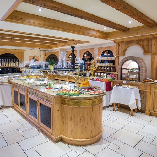 Ein großzügiges Buffet mit Speisen und Getränken in einem hellen, holzverkleideten Gourmetrestaurant.