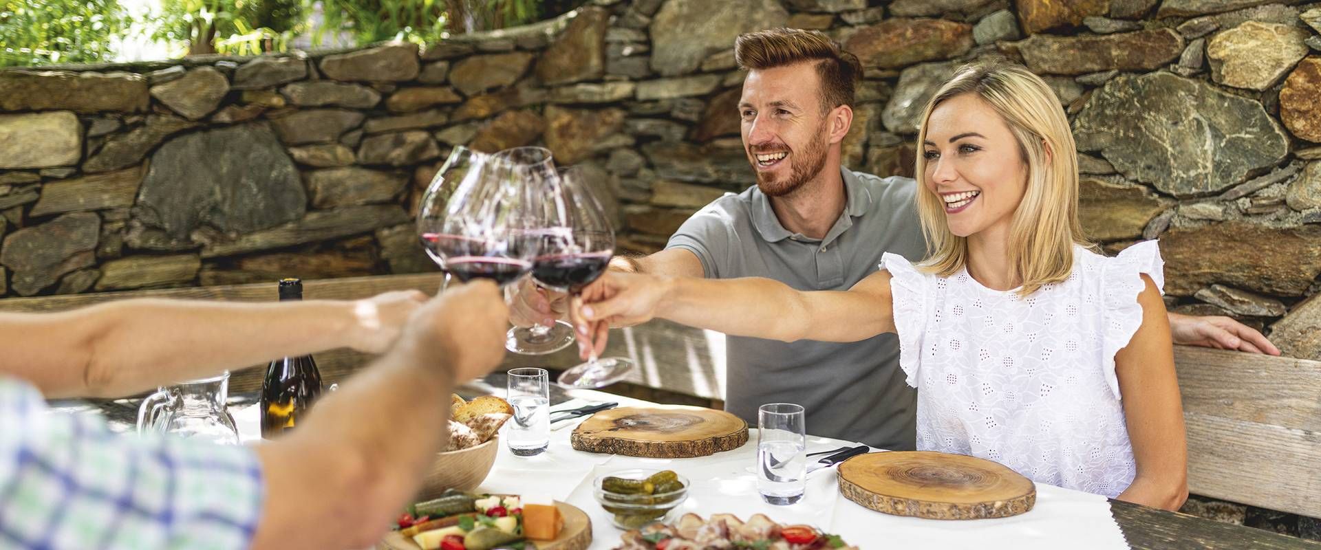Ein Paar stößt bei einer Weinverkostung im Vinum Hotel mit Rotwein an.