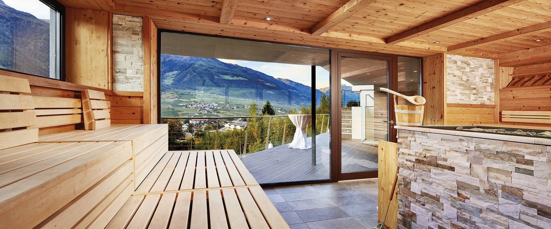 Holzsauna mit Panoramafenster und Blick auf die Berge, daneben eine offene Terrasse im Sauna Tower des Preidlhof.
